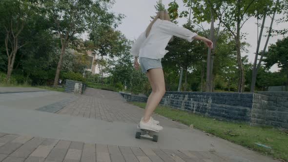 Asian woman sport skater feels happy to enjoy surfing skate for health at the street.