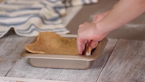 A Woman Puts the Dough in a Metal Form Before Baking