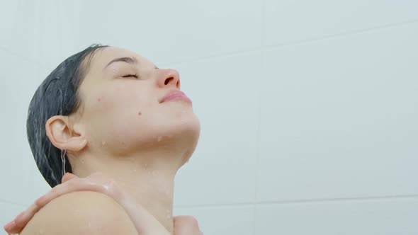 Young Woman Enjoying Process of Taking Shower in Bathroom
