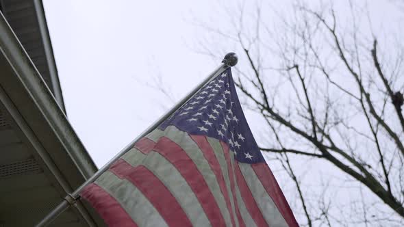 Close Up Shot of American Flag on a Front Porch on a Breezy Day alt