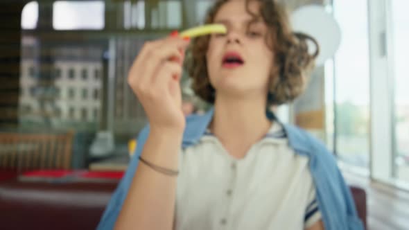 Young Funny Happy Woman Eat French Fries at Cafe alt
