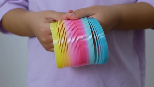 Slinky rainbow toy from the '90s. A multicolored children's spiral toy. alt