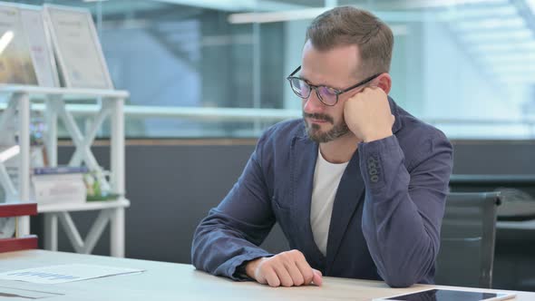 Middle Aged Businessman Falling Asleep While Sitting in Office alt