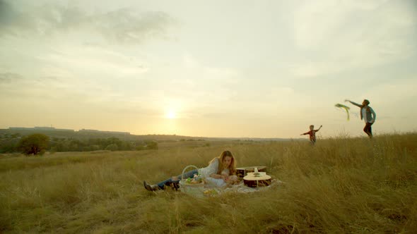 Woman with Baby Resting on Blanket During Family Picnic