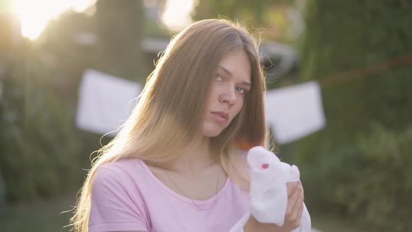 Young Slim Woman in Sunrays Cleaning Hands in Slow Motion Looking at Camera alt