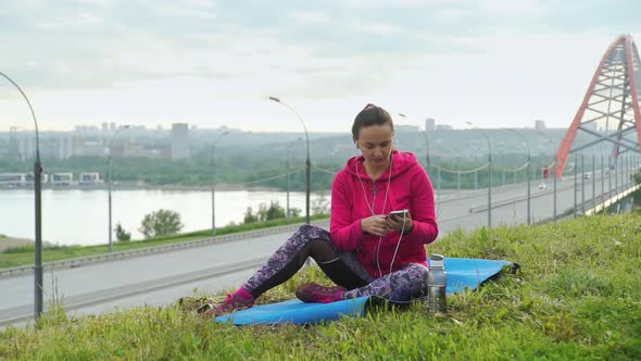 Fit Woman Listening Music While Workout at Park alt