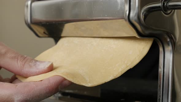 Kitchen helper machine for pasta 4K 2160p 30fps UltraHD footage - Close-up of dough processing for I alt