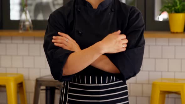 Beautiful waitress standing with arms crossed in cafe 4k alt