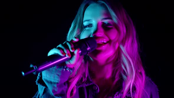 Live Vocal Performance of Singer in Darkness Vocalist Cute Girl in Neon Light Dancing Singing alt