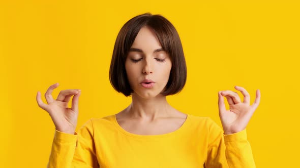 Young Woman Meditating Calming Down Relaxing Posing Over Yellow Background alt
