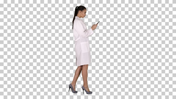 Cheerful Cute Young Woman Doctor Typing Text on Phone While alt