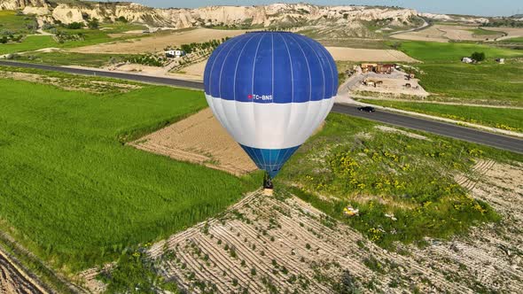 Hot air balloons fly over the mountainous landscape of Cappadocia, Turkey. alt