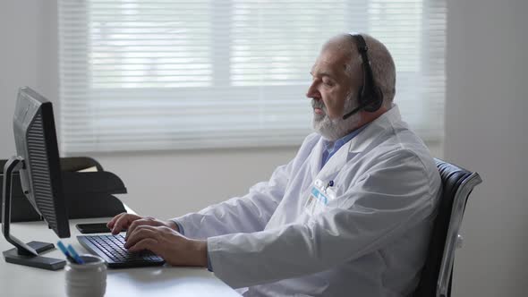Medicine Technology and Healthcare Concept Senior Male Doctor or Nurse with Headset and Computer alt
