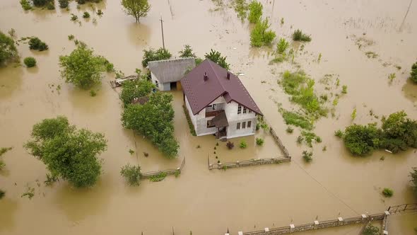 Aerial view of flooded house with dirty water all around it alt