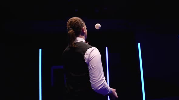 Circle Movement Camera Around Professional Circus Performer Juggling White Balls Against a Black alt