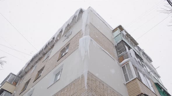 Large Isicles on Russian Chrushevka 5Storey Building Corner at Winter Day Snowfall