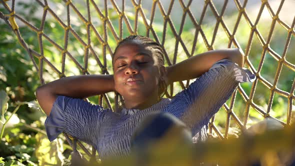 Relaxed Happy African American Young Woman Lying in Hammock with Closed Eyes Smiling alt