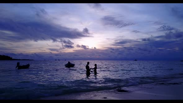 Man and woman engaged on perfect coastline beach trip by blue sea with white sandy background of the alt