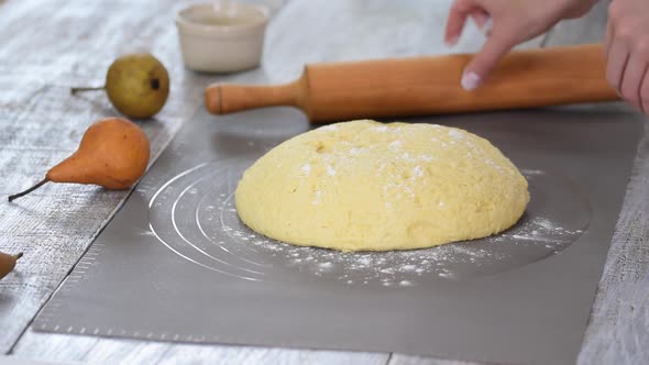 Woman chef with raw dough. Young female preparing bread dough on table.
