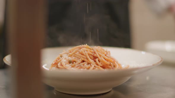 Closeup of the chef preparing spaghetti pasta with parsley and cheese