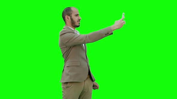 Young Businessman Taking Selfies on Phone on a Green Screen, Chroma Key alt