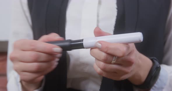 School Teacher in White Blouse with Neat Manicure Stands IN Classroom and Openscloses Black alt