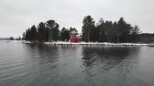 4k drone video of Sandpoint Lighthouse in Baraga, Michigan in the winter. alt