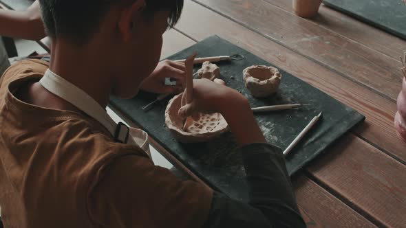 Boy Carving Pattern on Bowl of Clay alt