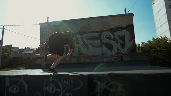 Young parker freerunner runs on the roofs of garages and does somersaults alt