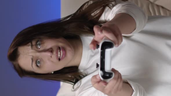 Vertical Shot Joyful Attractive Woman in White Pajamas Plays Video Games with Joystick in Bed