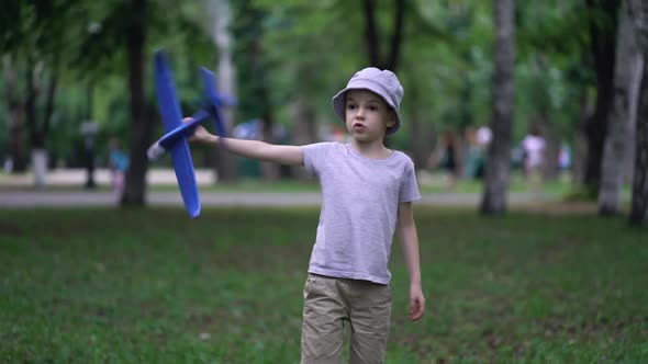 Boy Playing in the Park with a Toy Plane