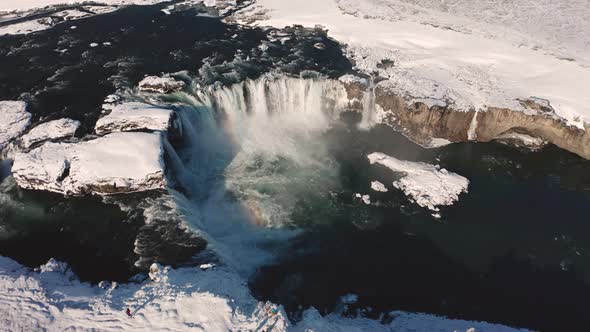 Aerial View of Godafoss Waterfall with Snowy Shore and Ice, Iceland, Winter 2019