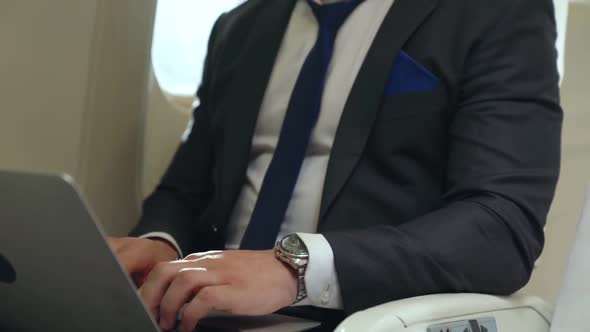 Young Businessman Using Laptop Computer in Airplane alt