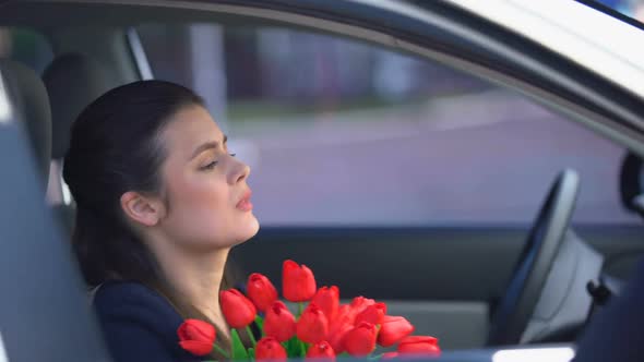 Offended Lady With Bunch of Tulips Sitting Into Car, Male Trying to Apologize alt