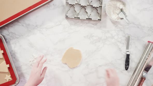 Flat lay. Rolling out sugar cookie dough to bake Christmas cookies. alt