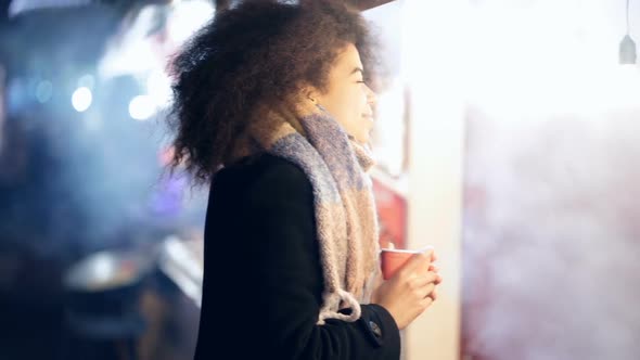 Woman standing near the grill.