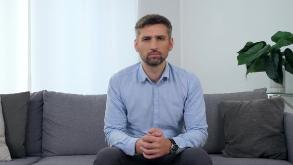 Portrait Adult Man Patient Sitting on Couch in Clinic Office Looking Camera alt