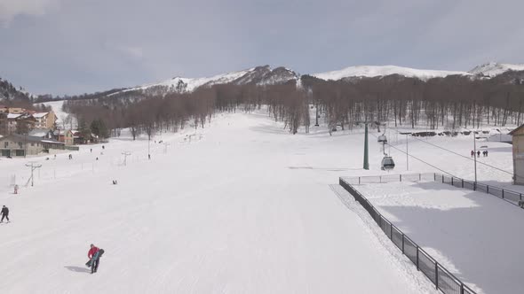 Flying over rope-way with gondolas at mountain resort Crystal Park in Bakuriani. Snowy winter day. alt