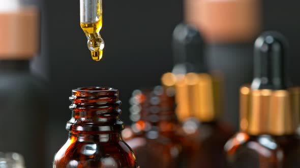 Super Slow Motion Shot of Oily Essence Drop Into Phial on Dark Background at 1000Fps alt