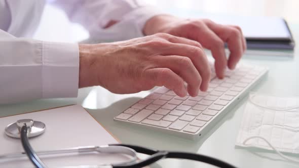 Doctor At The Desk Typing On The Keyboard alt