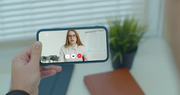 Hands of Male with Smartphone Study Online and Learns Video Lesson with Teacher Using Smartphone at alt