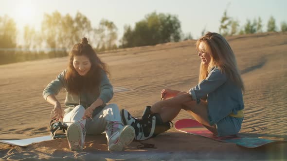 Two Pretty Girls with Sandboard in Dubai Desert at Sunset. Summer Vacation, Travel Lifestyle and alt