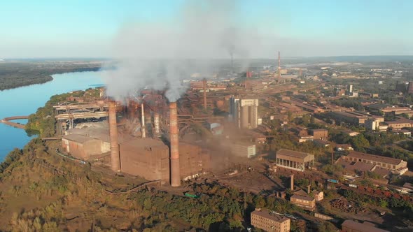 Aerial View of the Industrial Plant with Smoking Pipes Near the City. Industrial Zone