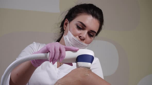 Beautiful Girl Beautician Conducts the Procedure of Laser Hair Removal Device