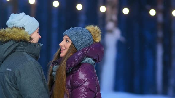 Lovely Couple in Warm Jackets Talks on Public Skating Rink alt