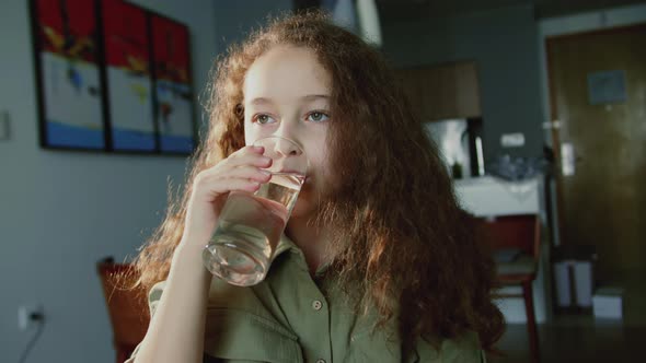 Cute Child Girl Drinking Glass Fresh Transparent Pure Filtered Mineral Water at Home alt