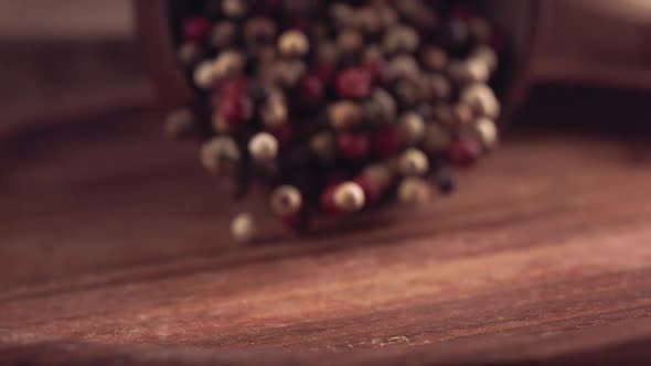 Colorful Pepper Falling on a Wooden Table alt