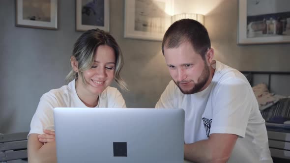 Serious young couple husband and wife pay bills online on website app doing paperwork planning alt