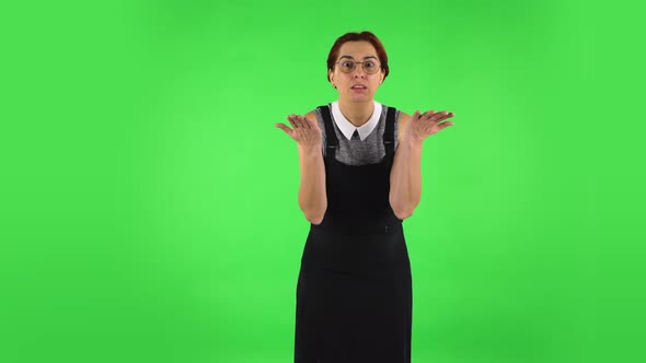 Funny Girl in Round Glasses Is Upset, Waving Her Hands in Indignation, Shrugging. Green Screen alt