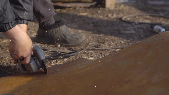 Man is Cutting a Piece of Iron with a Saw for Metal alt